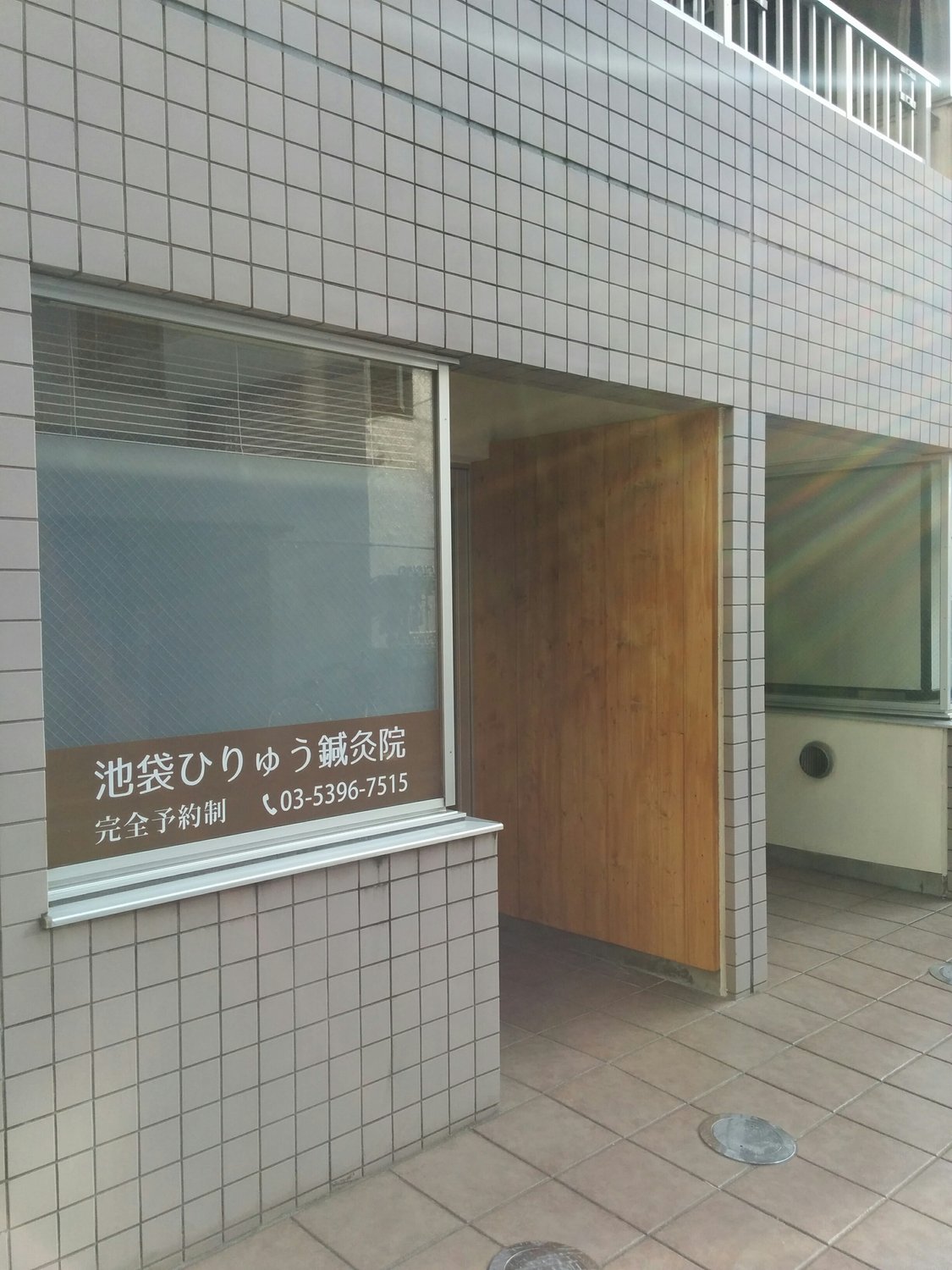 木の板が目印の池袋ひりゅう鍼灸院の入口